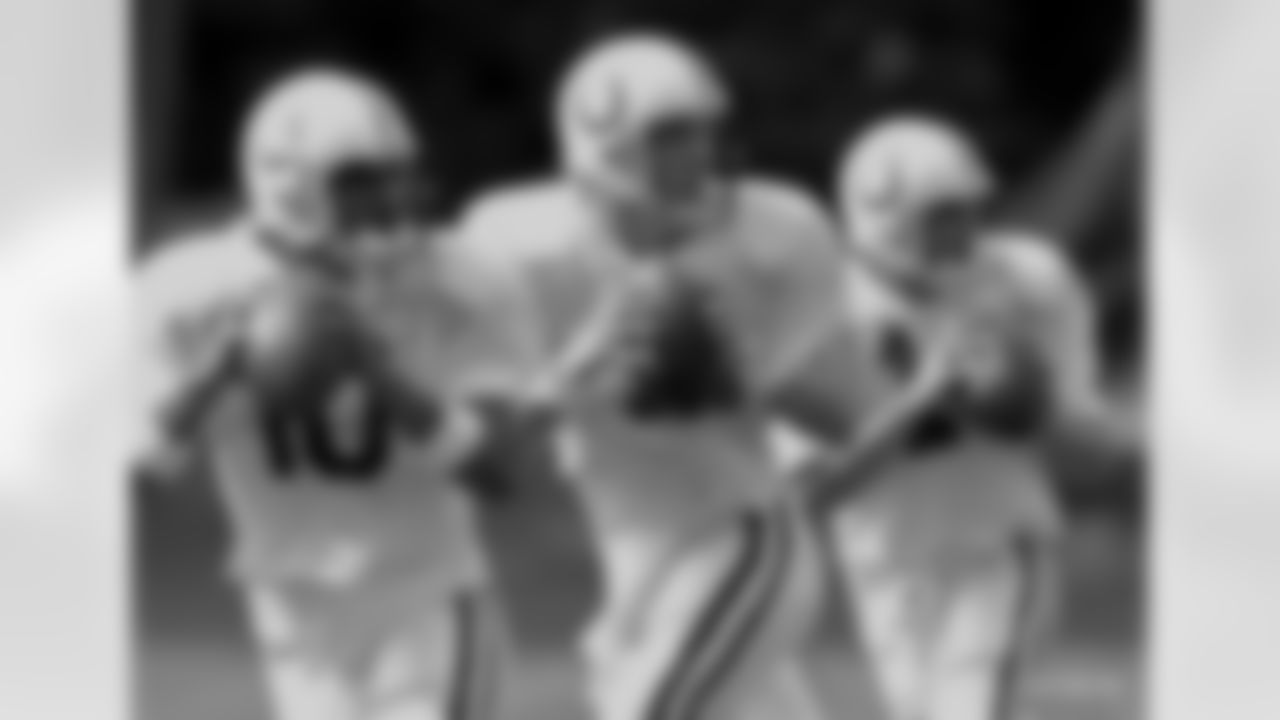 Indianapolis Colts starting quarterback Peyton manning, center drops back with backup quarterback Pete Gonzalez, left, and Kelly Hocomb during a drill at the teams' training camp in Terre Haute, Ind., Sunday, July 16, 2000. (AP Photo/Michael Conroy)