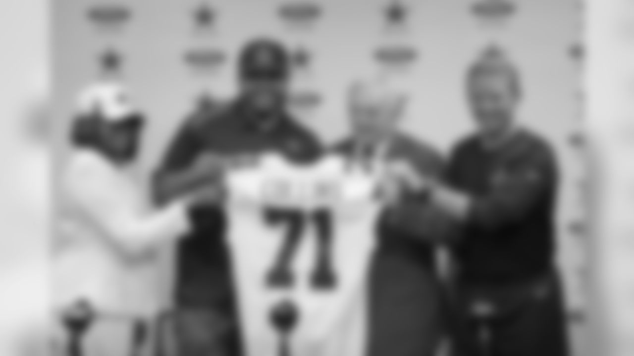 Dallas Cowboys undrafted free agent La'el Collins (in cap), his mother Loyetta Collins (left), Cowboys owner Jerry Jones (second from right) and Cowboys head coach Jason Garrett (right) hold Collins' jersey at Cowboys headquarters in Irving, Texas on Thursday, May 7, 2015. (AP Photo/James D Smith)