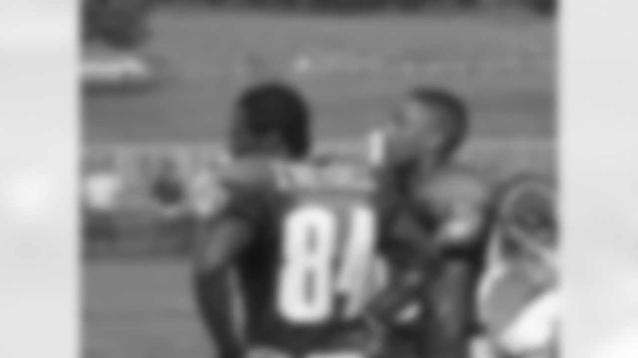 WRs Freddie Mitchell and Greg Lewis look on...