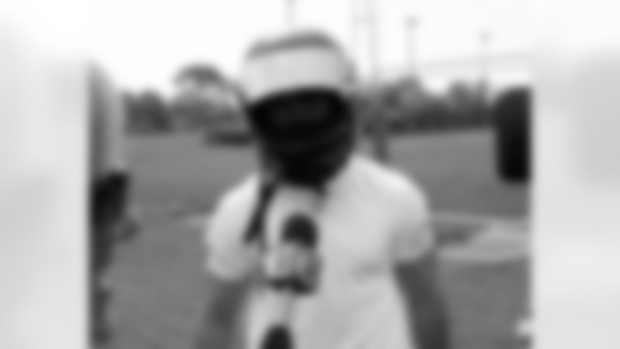 K David Akers tries out a special racing helmet given to him by NASCAR driver Martin Truex Jr.