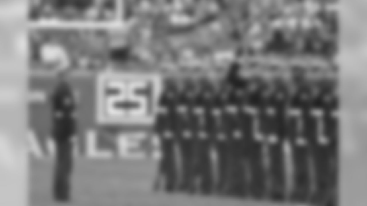 Service members go out onto the field and perform at halftime.