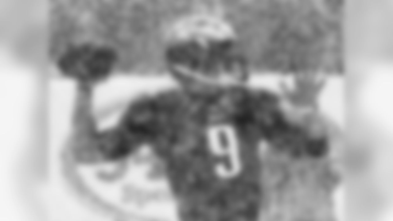 Eagles' QB Nick Foles throws a pass through the snow.