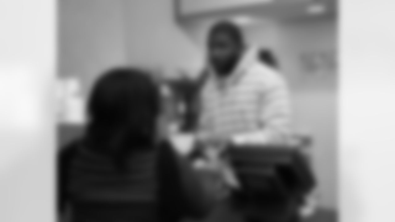 Akeem Jordan signs a hat for an Eagles fan at Dunkin' Donuts at 15th and Spring Garden