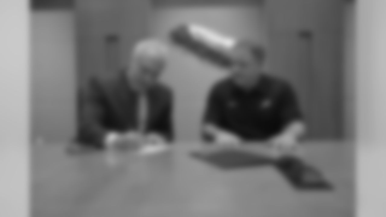 Chairman/CEO Jeffrey Lurie signs the contract to make Chip Kelly's hire official
