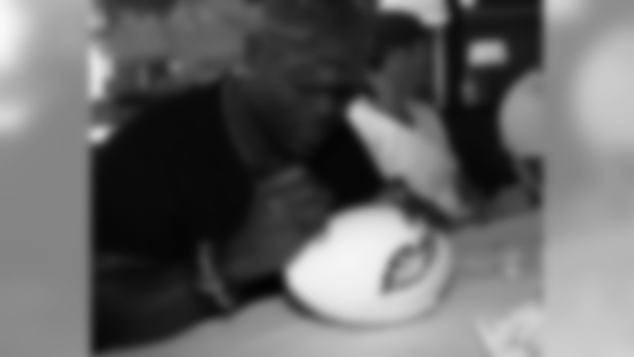 DE Hugh Douglas autographs a football