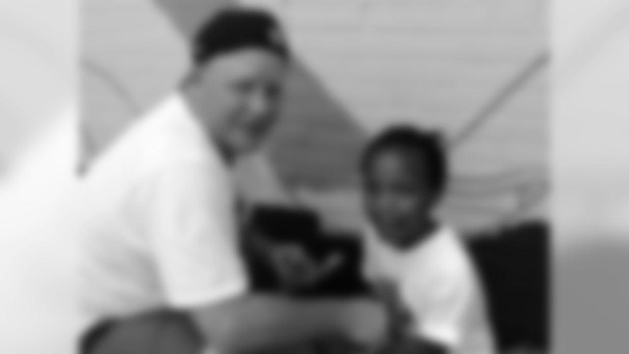 Head coach Chip Kelly works with this little girl on the wall mural