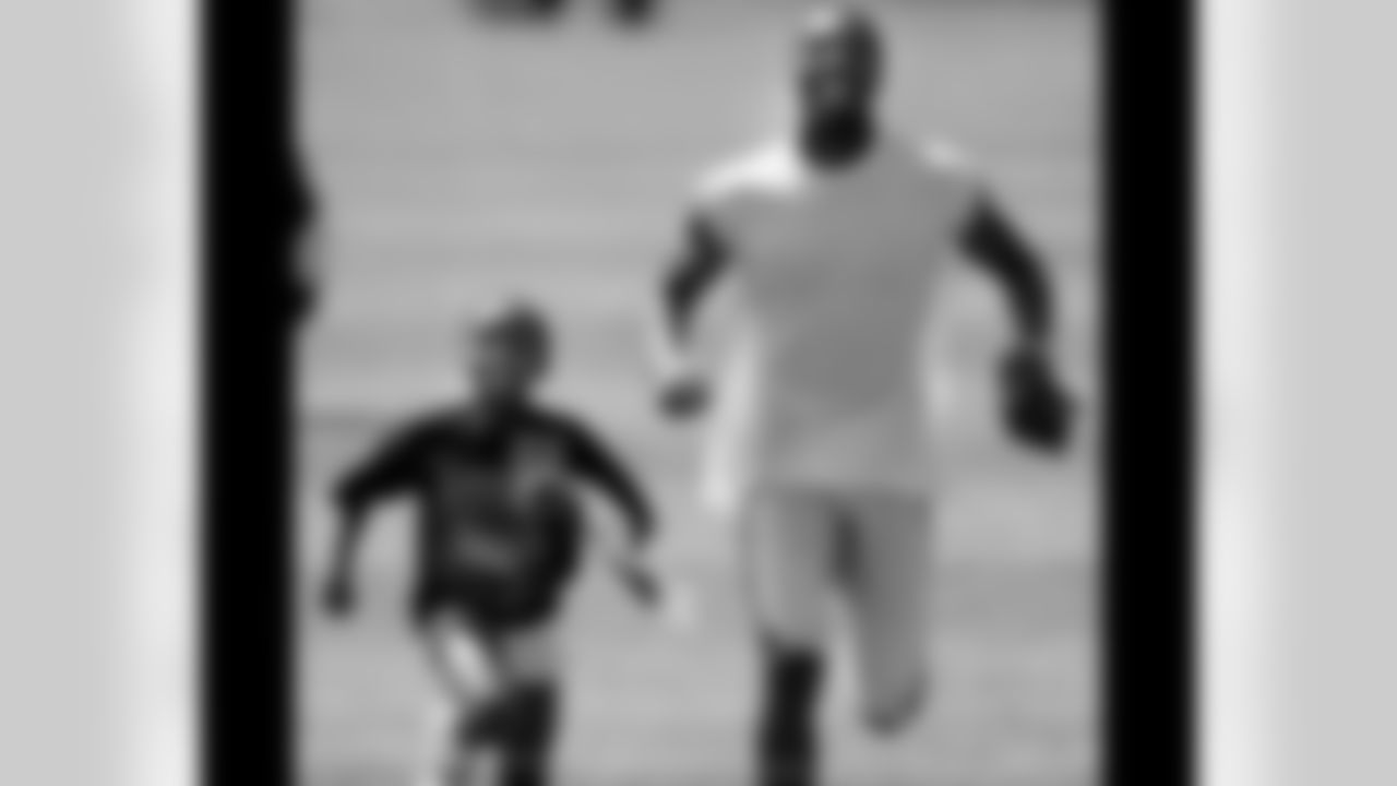 WR Greg Lewis runs with a fan after practice