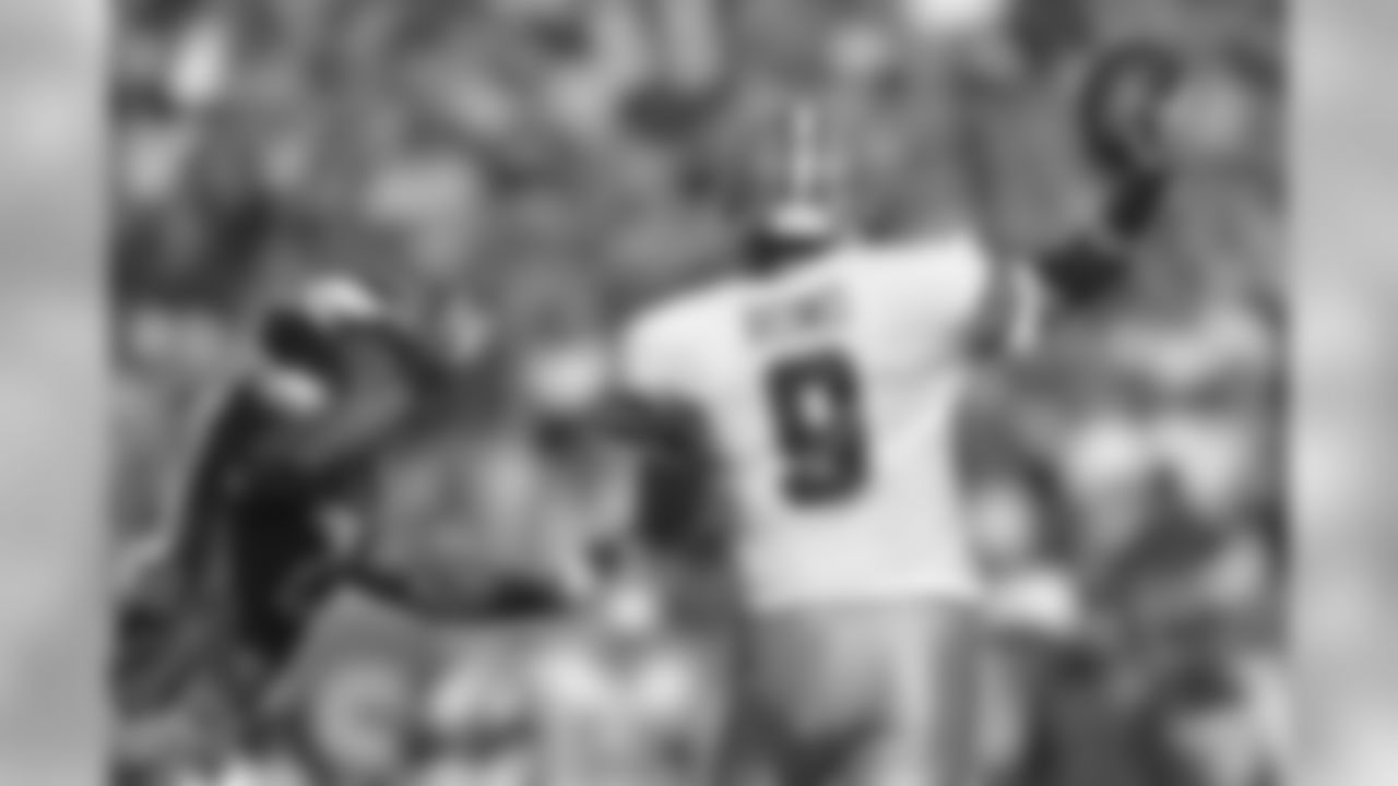 Cowboys' QB Tony Romo being contested as he throws the football.