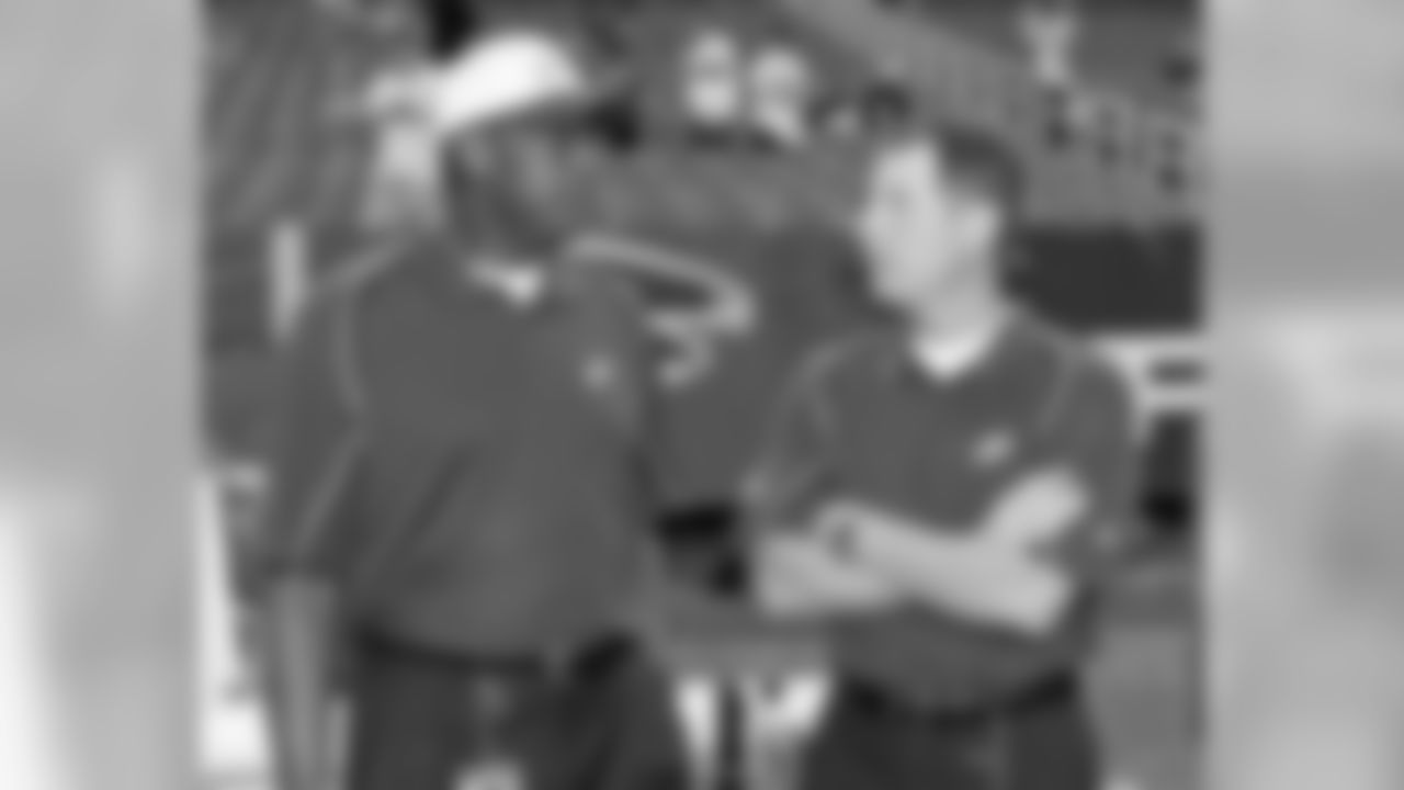 Eagles Director of Player Programs Harold Carmichael and QB coach Pat Shurmur chat on the sideline