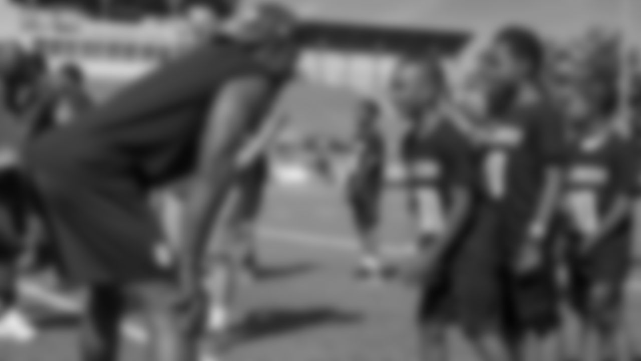 Former Eagles WR Jason Avant coaches a camp participant during a drill