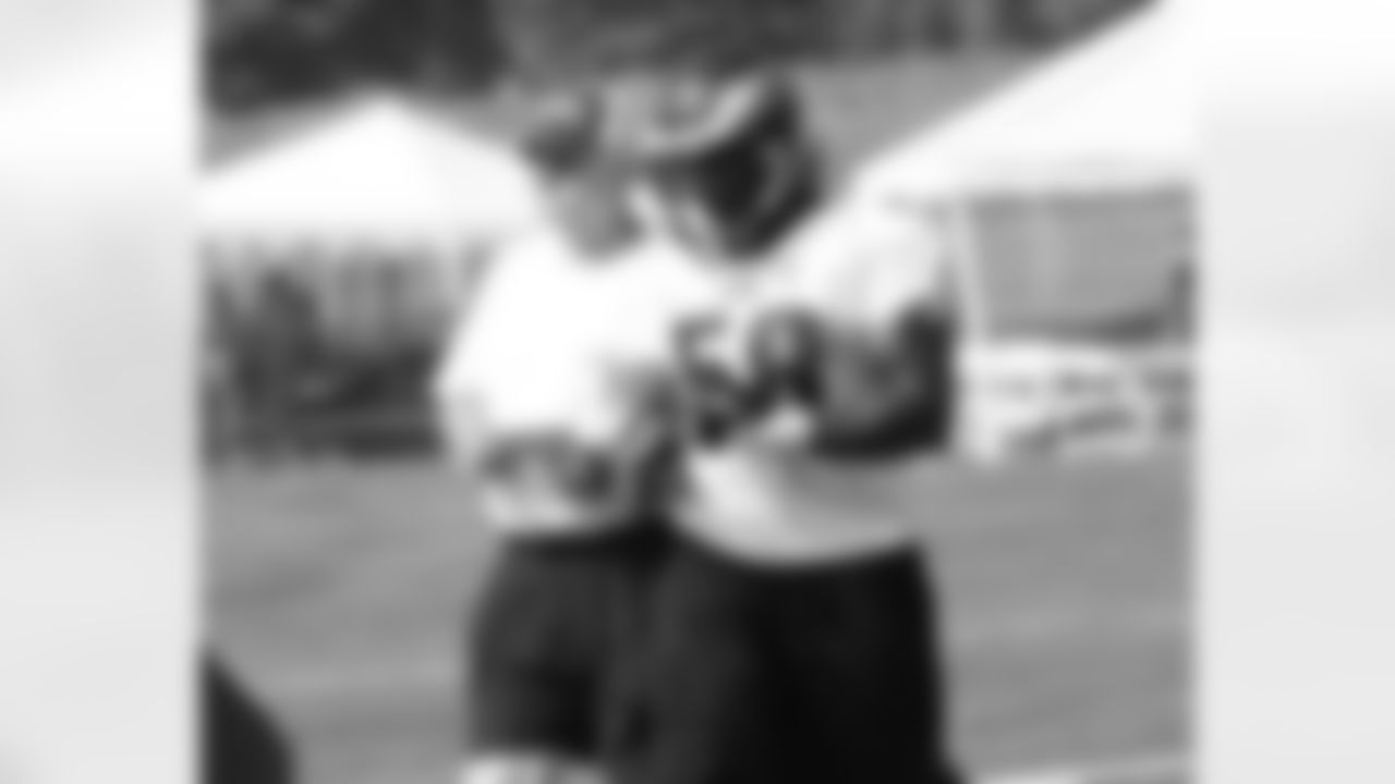 DE Trent Cole receives instruction from D-line coach Tommy Brasher
