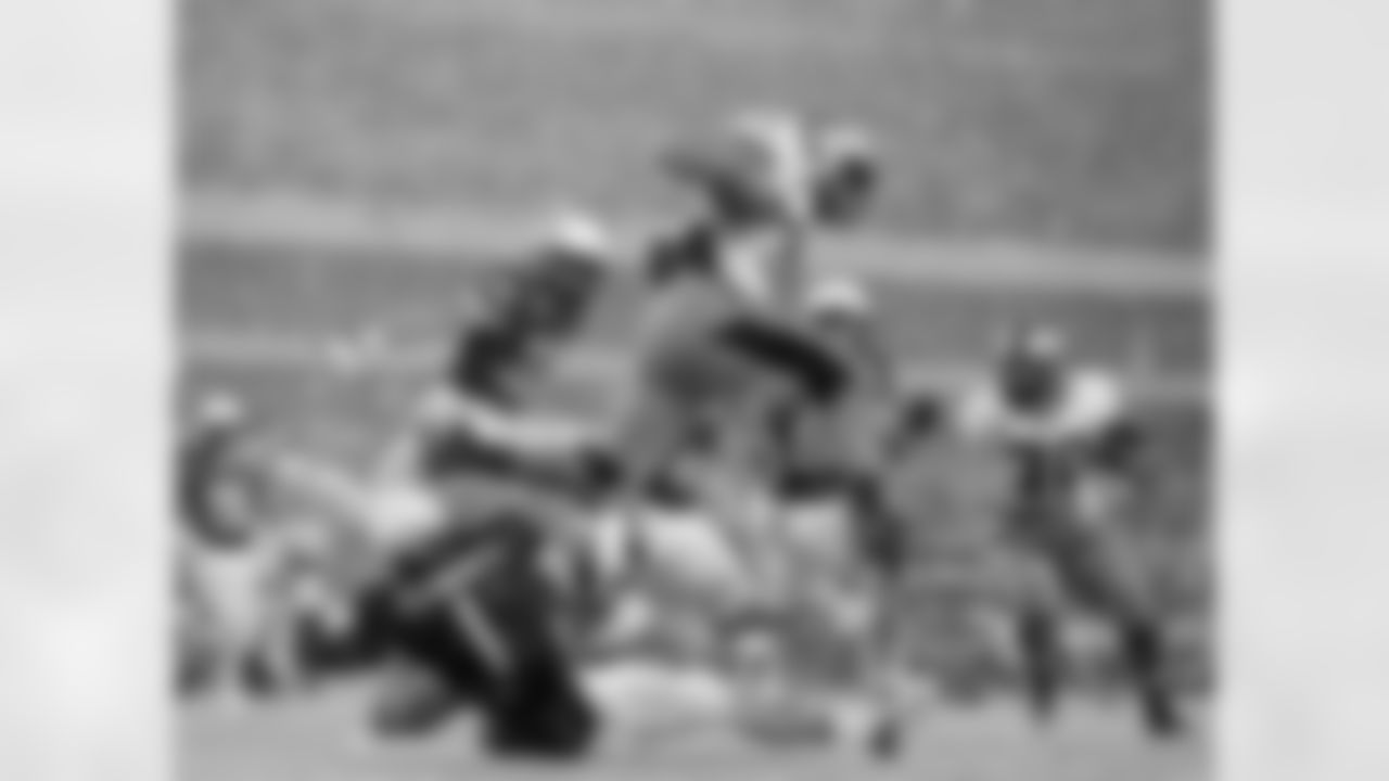 Army running back Terry Baggett jumps over defender Navy cornerback Brendon Clements