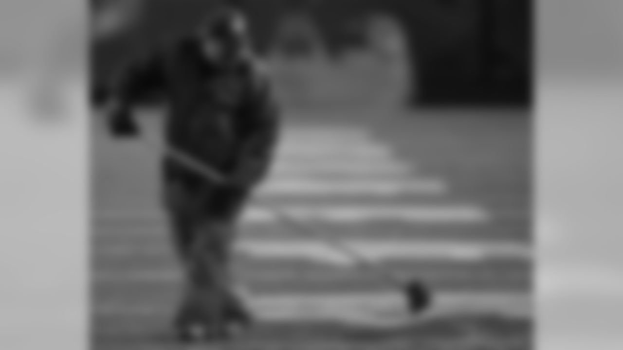 Groundscrewman works on the puddles that formed on Giants Stadium surface