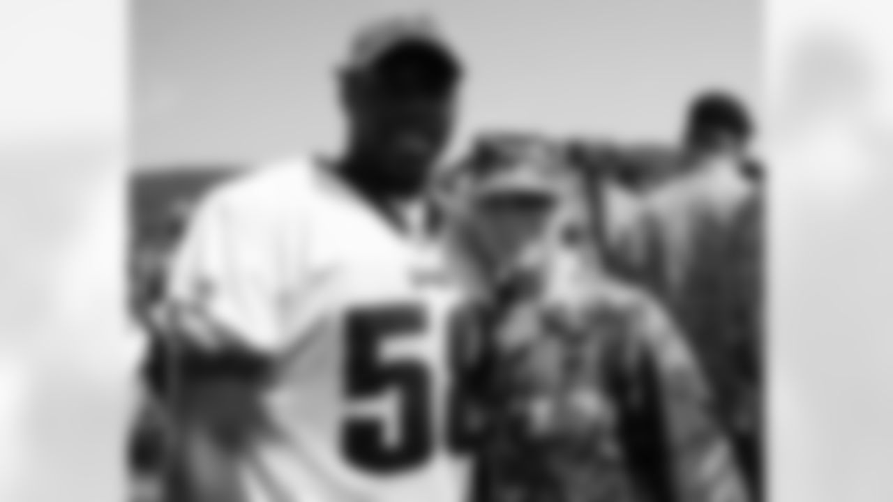 U.S. Army member poses for a photo with DE Trent Cole