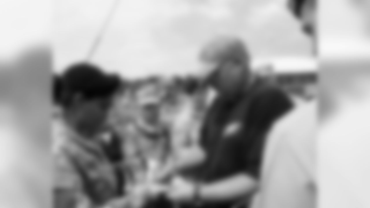 Head coach Andy Reid signs some autographs for military personnel at camp