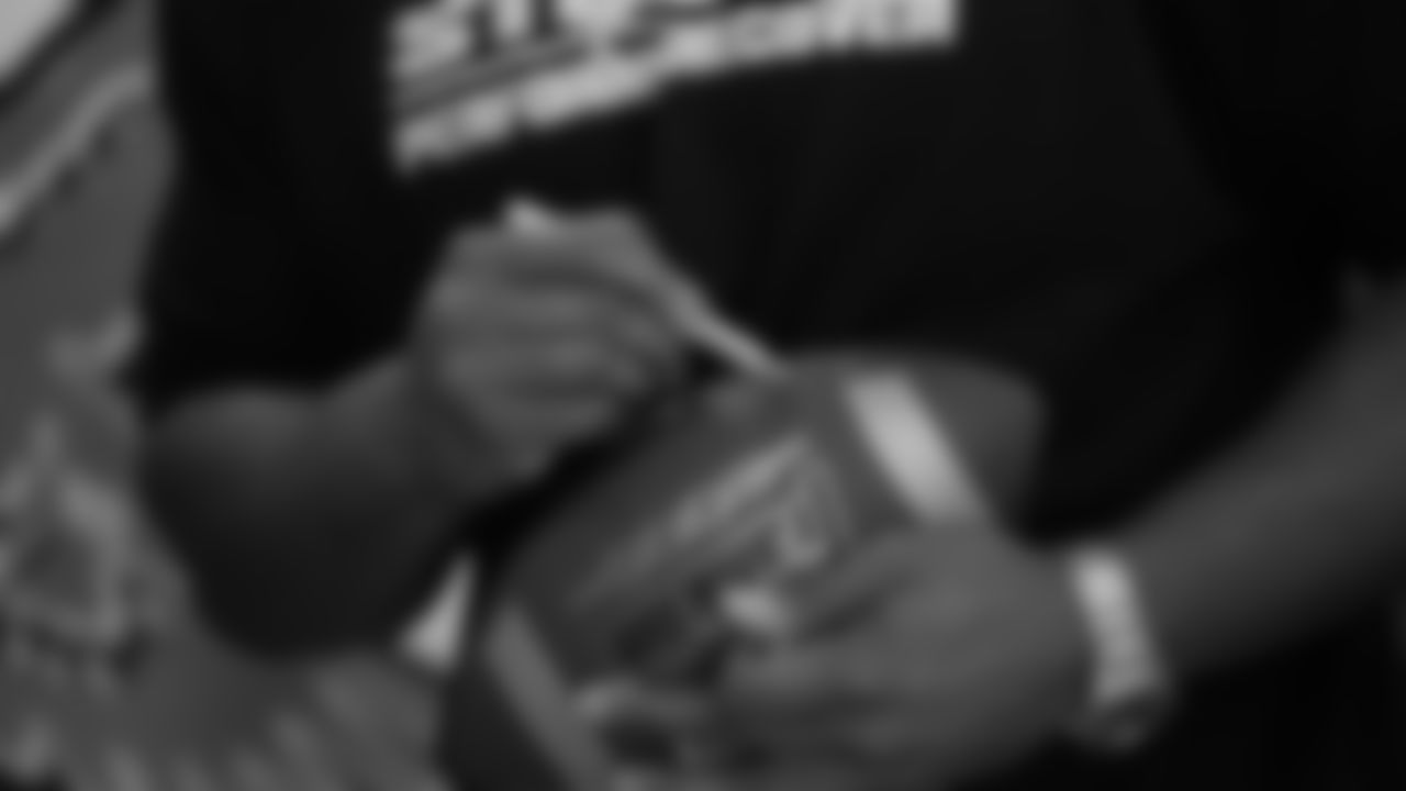 Dean signs a football.