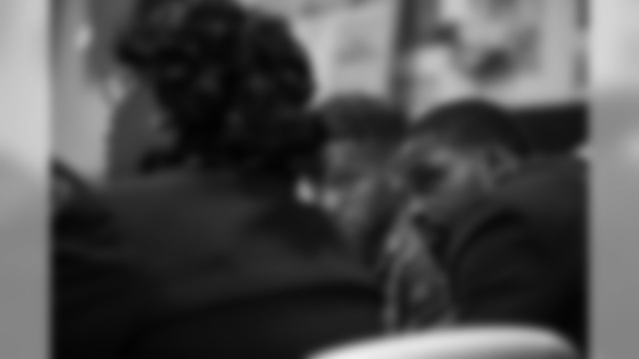 Torrey Smith listens to Reverend Michelle Simmons, founder and CEO of Why Not Prosper.