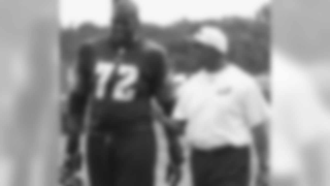 OT Tra Thomas walks off the field with offensive line coach Juan Castillo