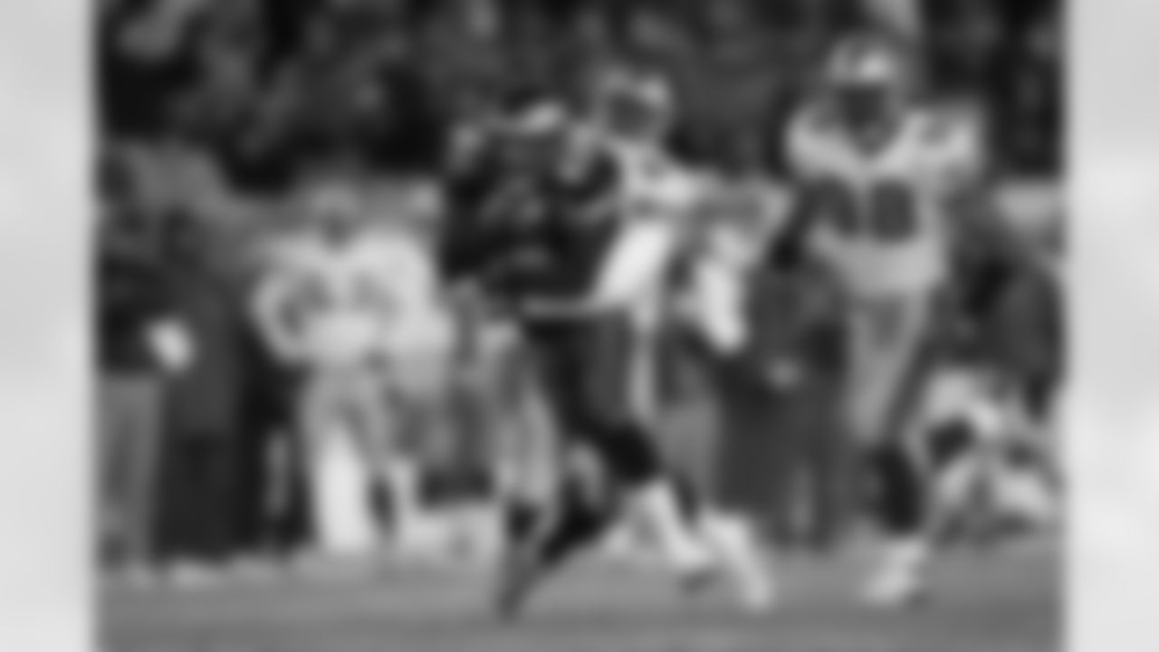 WR Greg Lewis holding on to the ball as he moves up the field