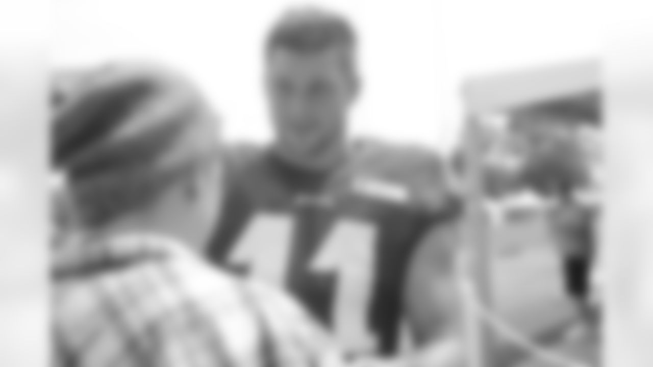 QB Tim Tebow enjoys a conversation with a lucky fan