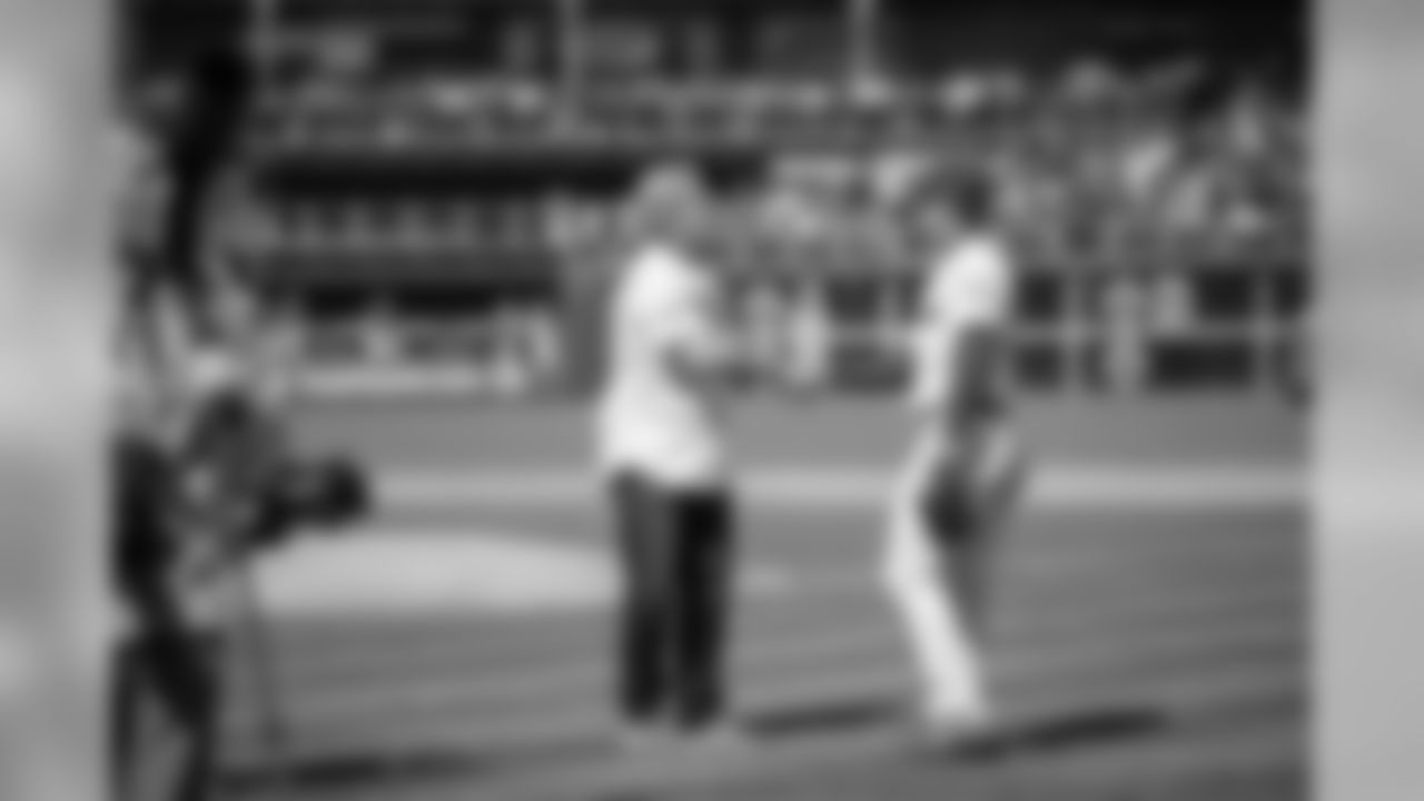 Coach Pederson meets with Phillies outfielder Rhys Hoskins after throwing out the first pitch.
