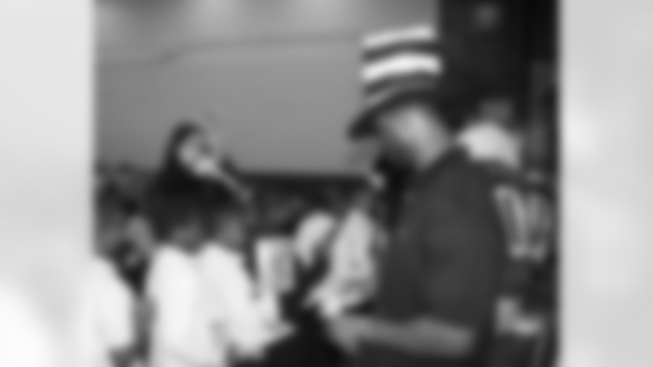 Students show their books to Omar and Swoop