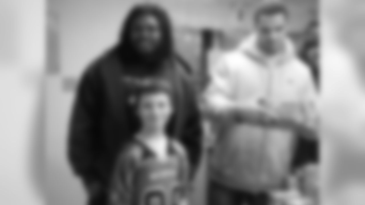 Jeff Owens, #64, and Clay Harbor, #82, pose for pictures and sort through gifts.