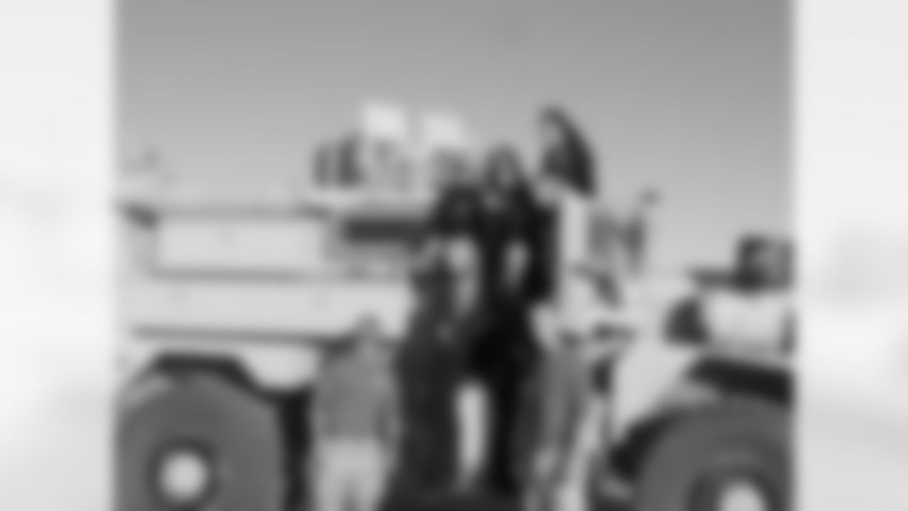 Eagles Cheerleaders pose next to an armored vehicle