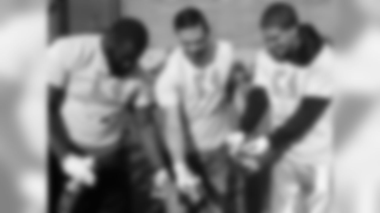 Burton, Bennie Logan and Mark Sanchez work together on their socks