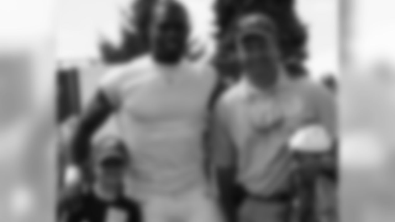 Father and son pose for a photo with DE Trent Cole