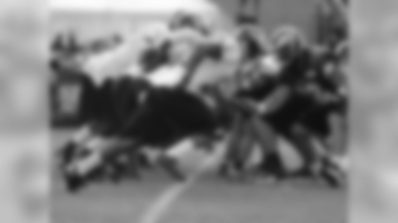 The defense rushes past the line of scrimmage as the ball is snapped