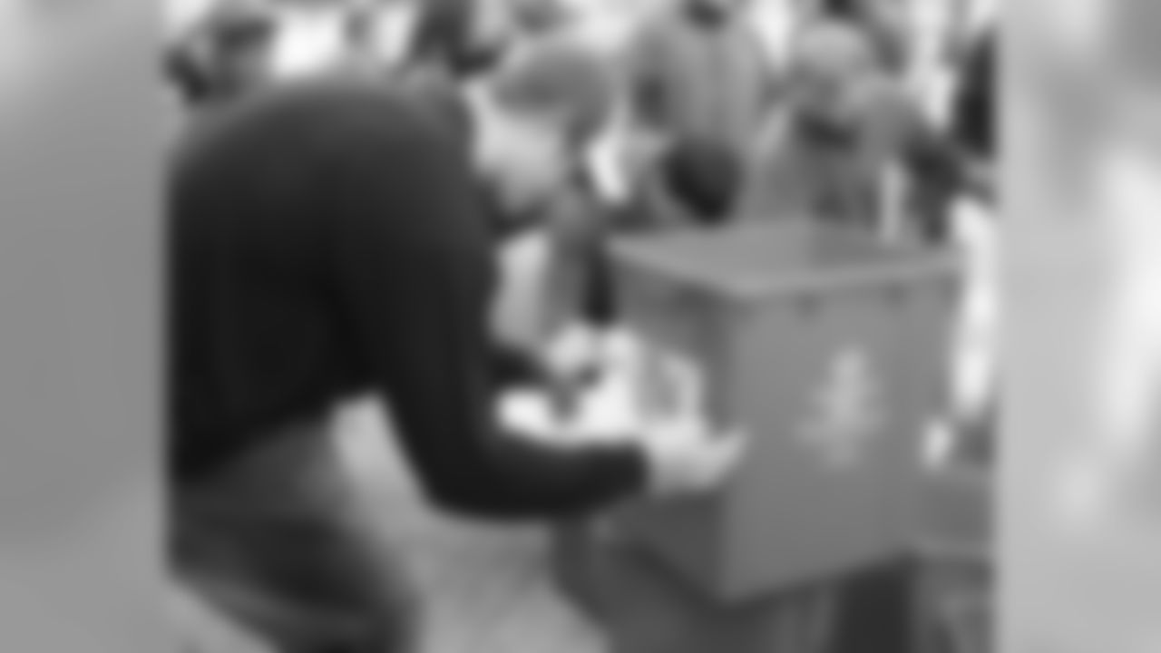 Celek applies the team's GO GREEN logo on the bins before they were distributed.