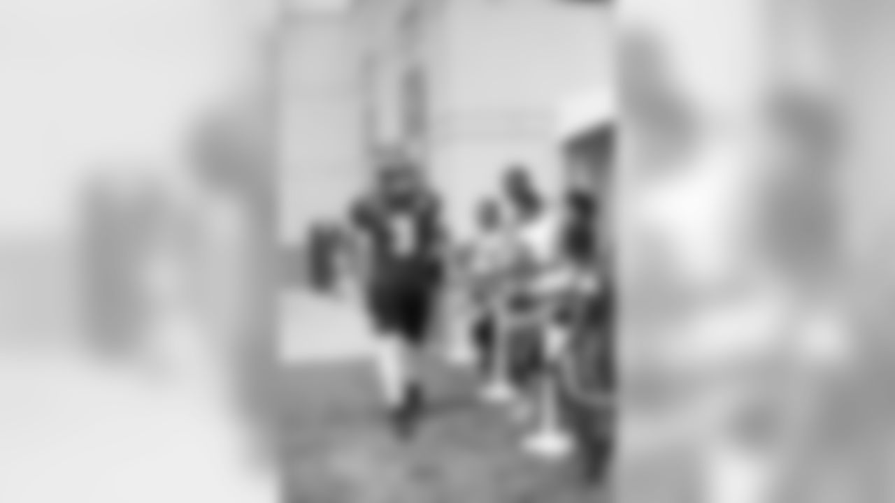 QB Mark Sanchez dishes out some low-fives to children from the C.H.E.E.R.S. program as he takes the field.