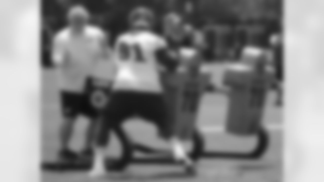 Defensive line coach Jerry Azzinaro watches defensive end Fletcher Cox on the sled