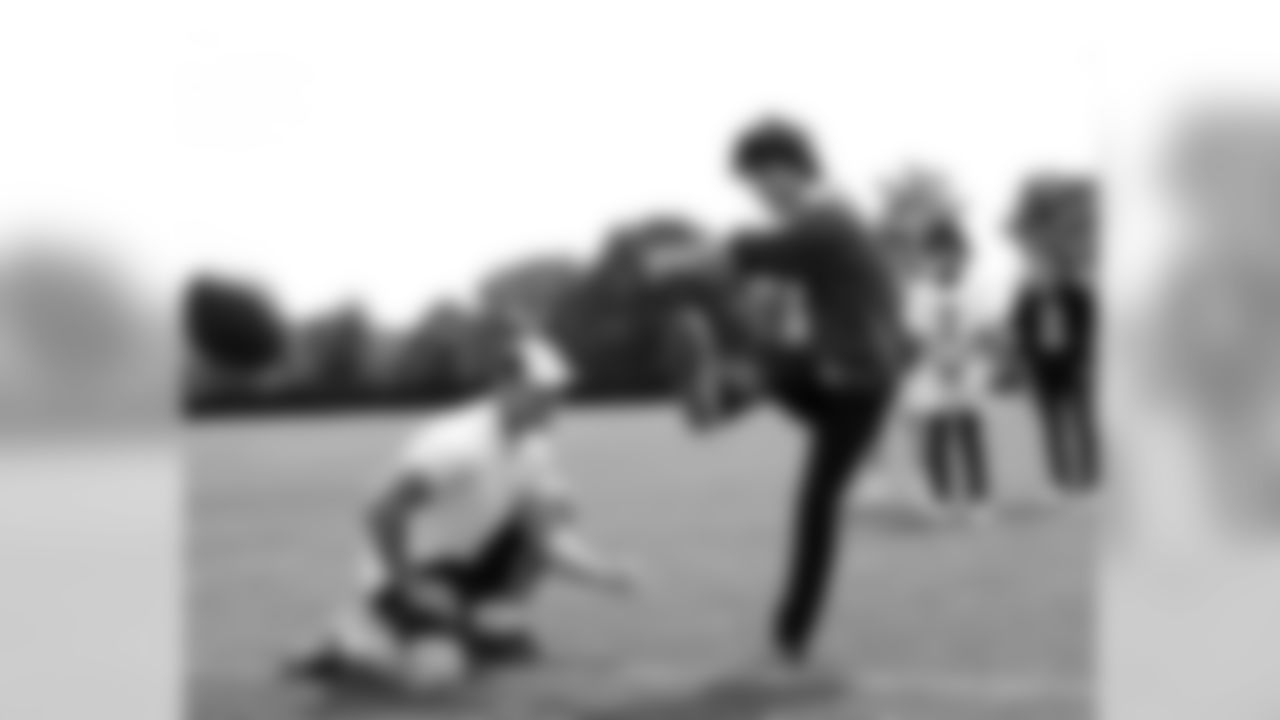 K David Akers holds as Nick Jonas launches kick