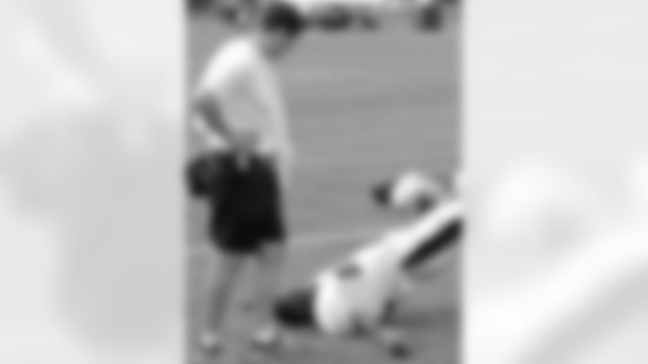 Assistant athletic trainer Chris Peduzzi watches the players stretch after practice