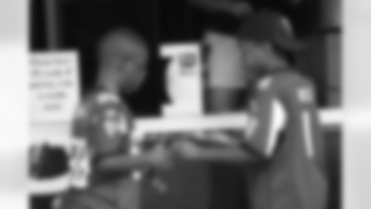 Two young Falcons fans buy a ball to get autographs after practice