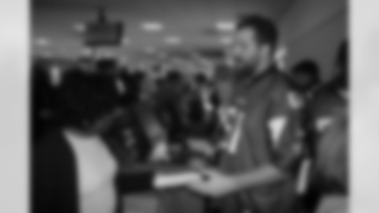 Several Falcons traded places with AirTran workers to marshal planes, take tickets and greet passengers // Trading Places - AirTran // Nov. 1, 2011 // Atlanta -