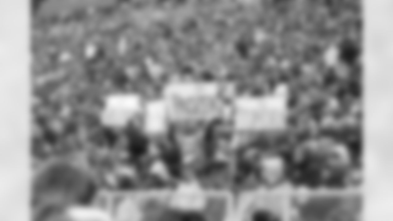 Fans at Lambeau Field hold up signs as snow falls in Green Bay