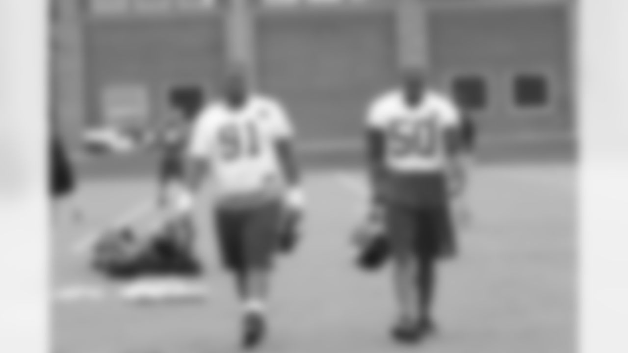 DT Corey Peters walks onto the field with DE Osi Umenyiora