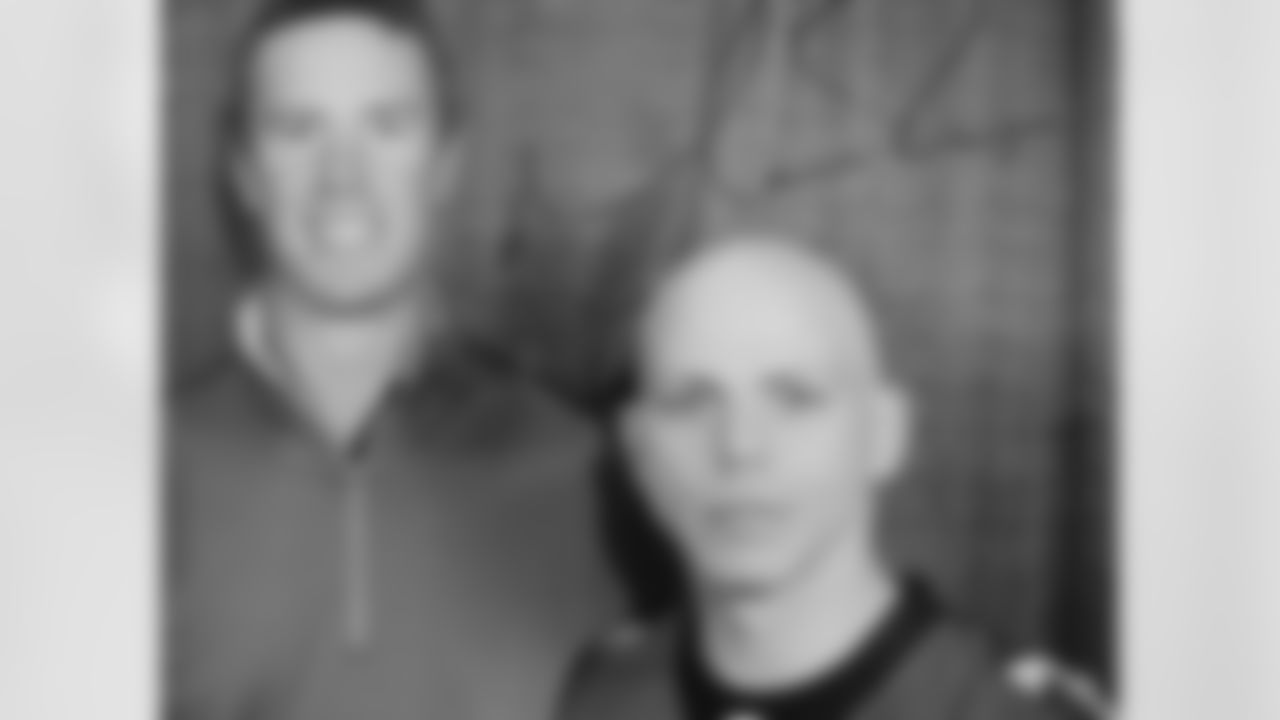 Stone Sour guitarist Josh Rand, right, displays a photo of himself with quarterback Matt Ryan that he had autographed