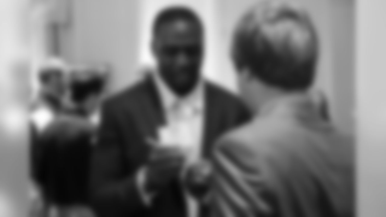 DE Jonathan Massaquoi signs a minihelmet for one of the guests at the Rookie Club dinner
