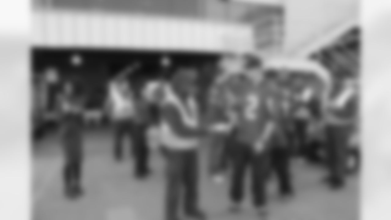 Several Falcons traded places with AirTran workers to marshal planes, take tickets and greet passengers // Trading Places - AirTran // Nov. 1, 2011 // Atlanta -