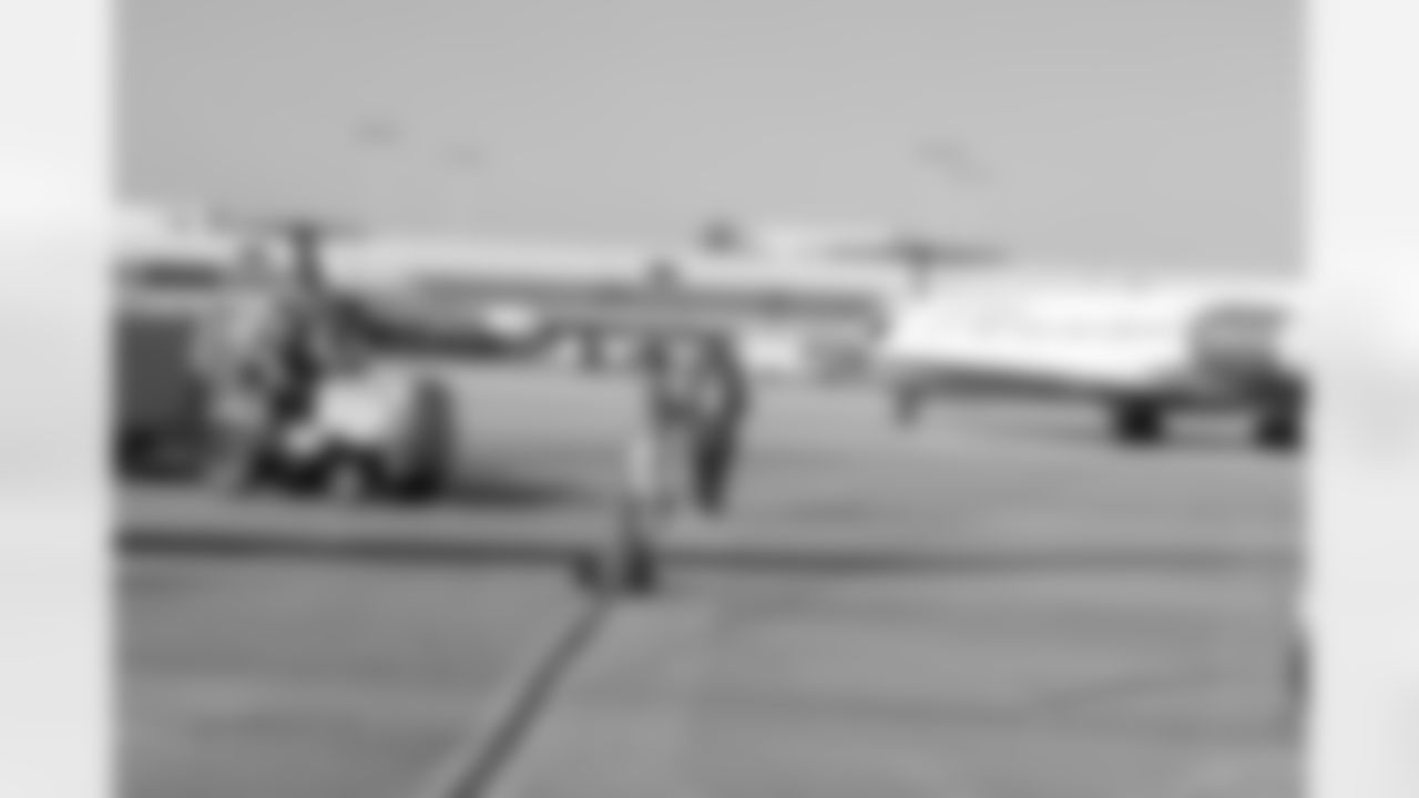 Several Falcons traded places with AirTran workers to marshal planes, take tickets and greet passengers // Trading Places - AirTran // Nov. 1, 2011 // Atlanta -