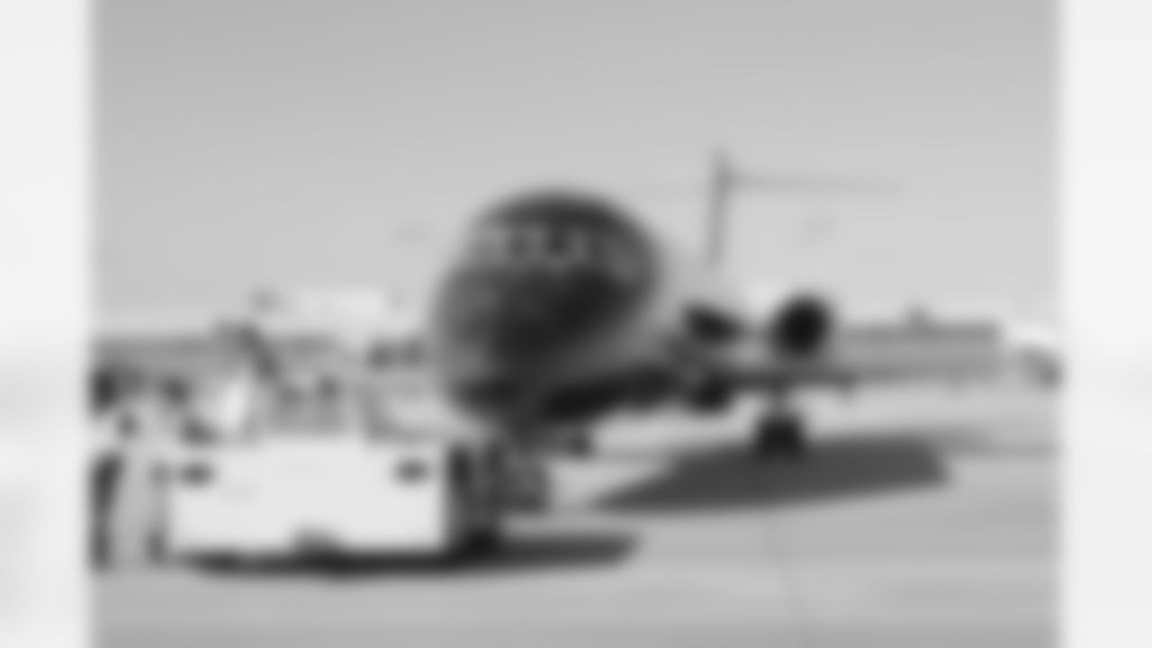 Several Falcons traded places with AirTran workers to marshal planes, take tickets and greet passengers // Trading Places - AirTran // Nov. 1, 2011 // Atlanta -