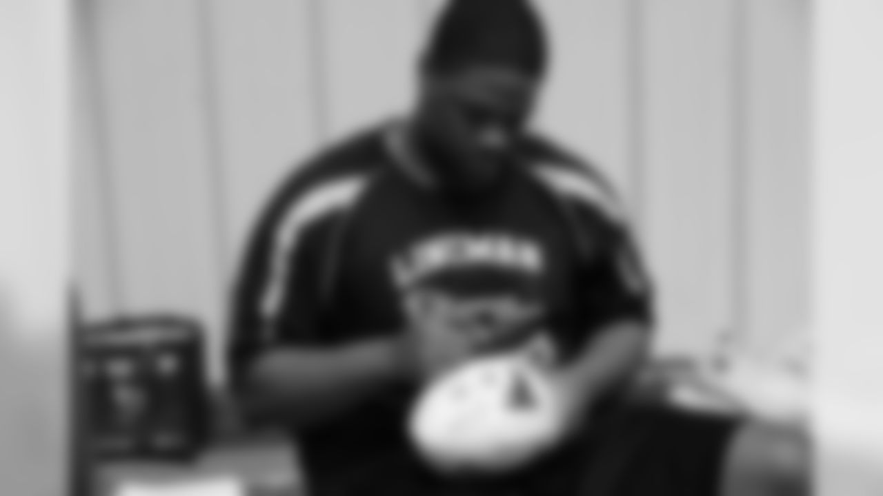 Corey Peters takes time to sign some footballs for Georgia Power associates as the Falcons lineman participated in Lineman Olympics with Georgia Power linemen Thursday for video features throughout the season in the Georgia Dome // Georgia Power Lineman O