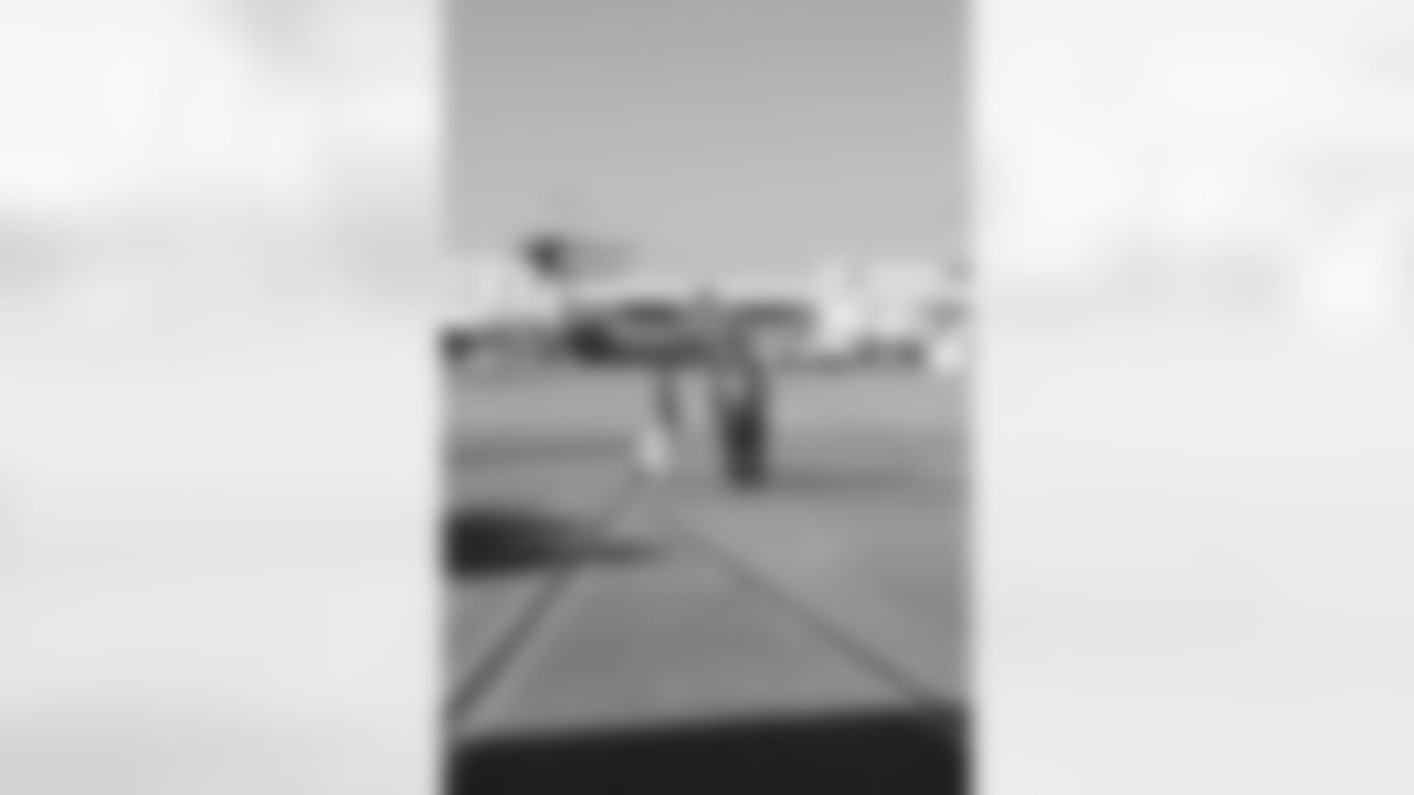Several Falcons traded places with AirTran workers to marshal planes, take tickets and greet passengers // Trading Places - AirTran // Nov. 1, 2011 // Atlanta -