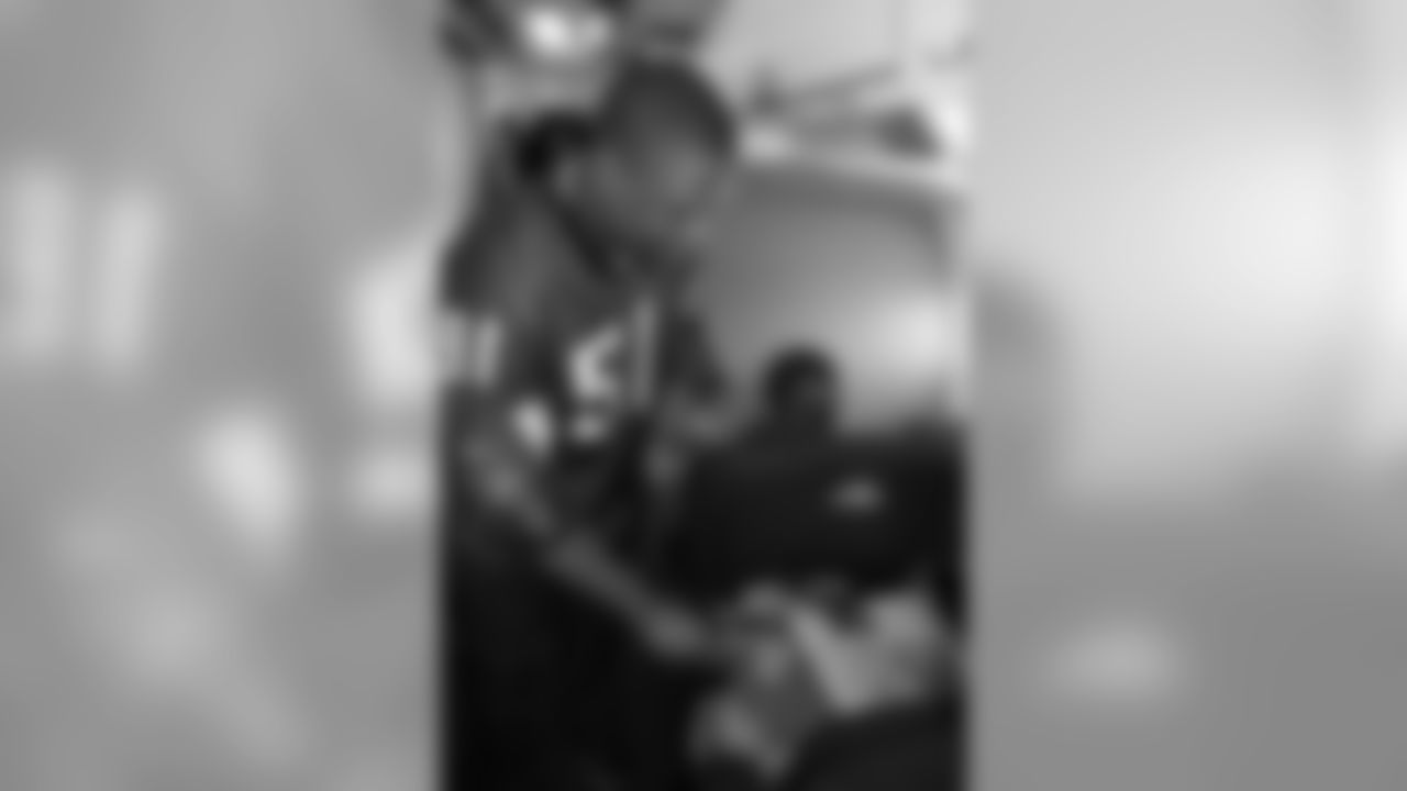 Several Falcons traded places with AirTran workers to marshal planes, take tickets and greet passengers // Trading Places - AirTran // Nov. 1, 2011 // Atlanta -
