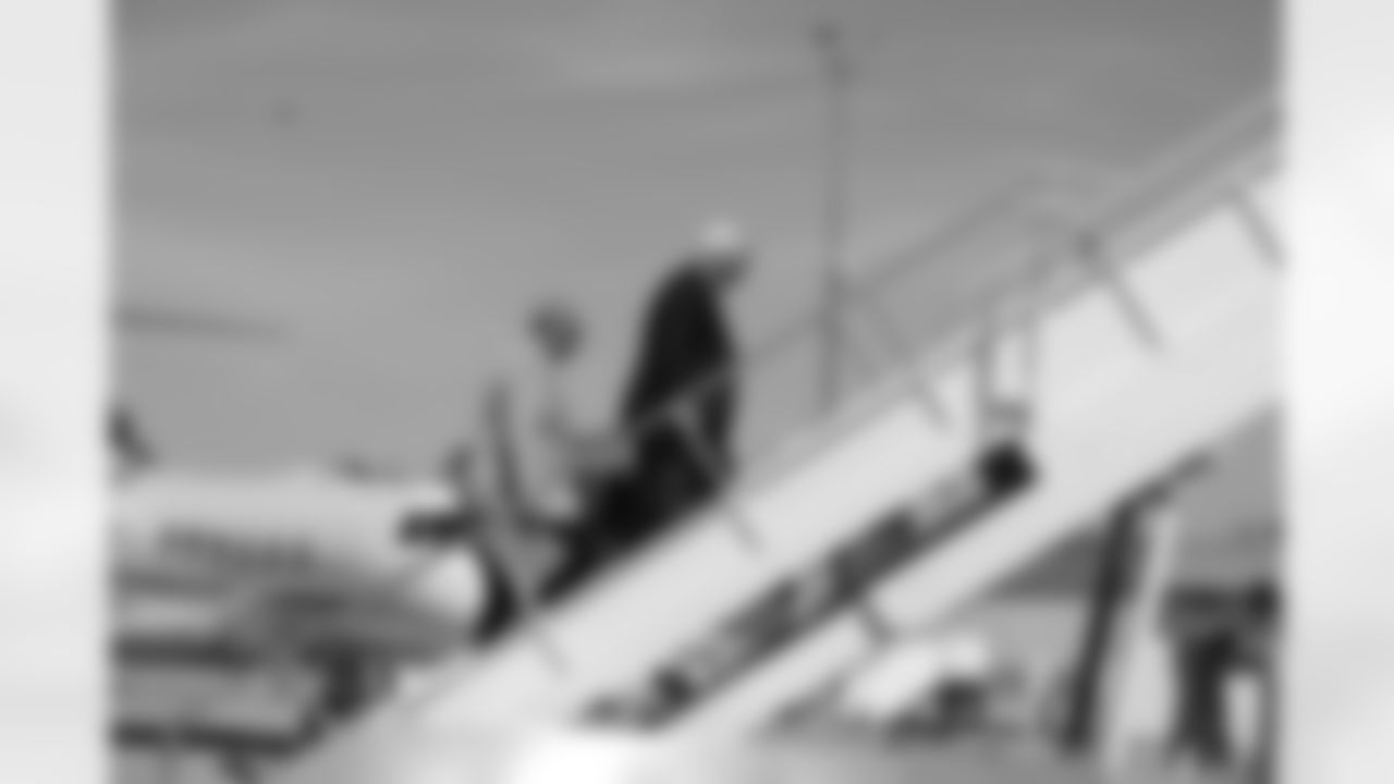 Head coach Mike Smith boards the plane