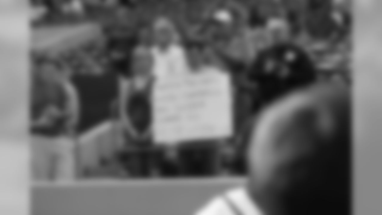 A fan holds a sign bearing the names of those who died during the Boston bombings and the police officer killed by the suspects